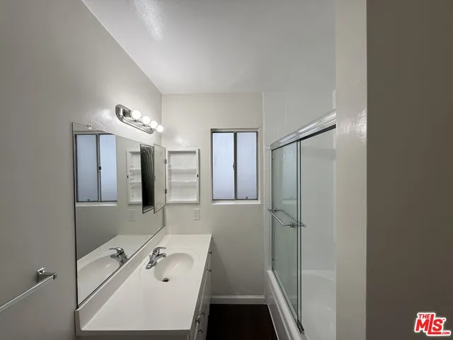a bathroom with a tub a sink and mirrors