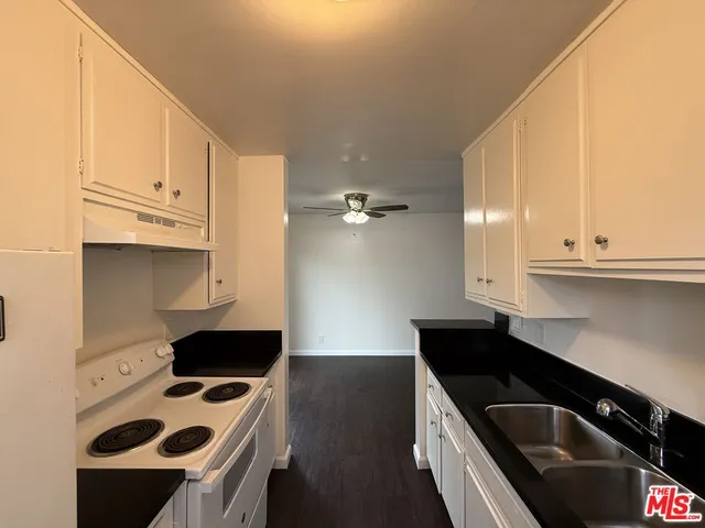 a kitchen with a sink a stove and cabinets