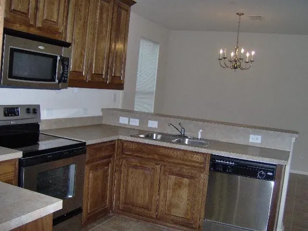 a kitchen with granite countertop a stove top oven microwave and cabinets