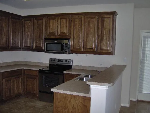 a kitchen with granite countertop wood cabinets and stainless steel appliances