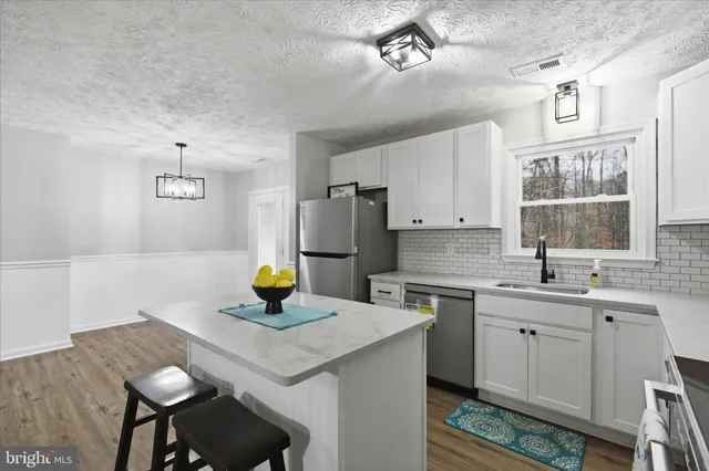 a kitchen with a sink refrigerator and cabinets