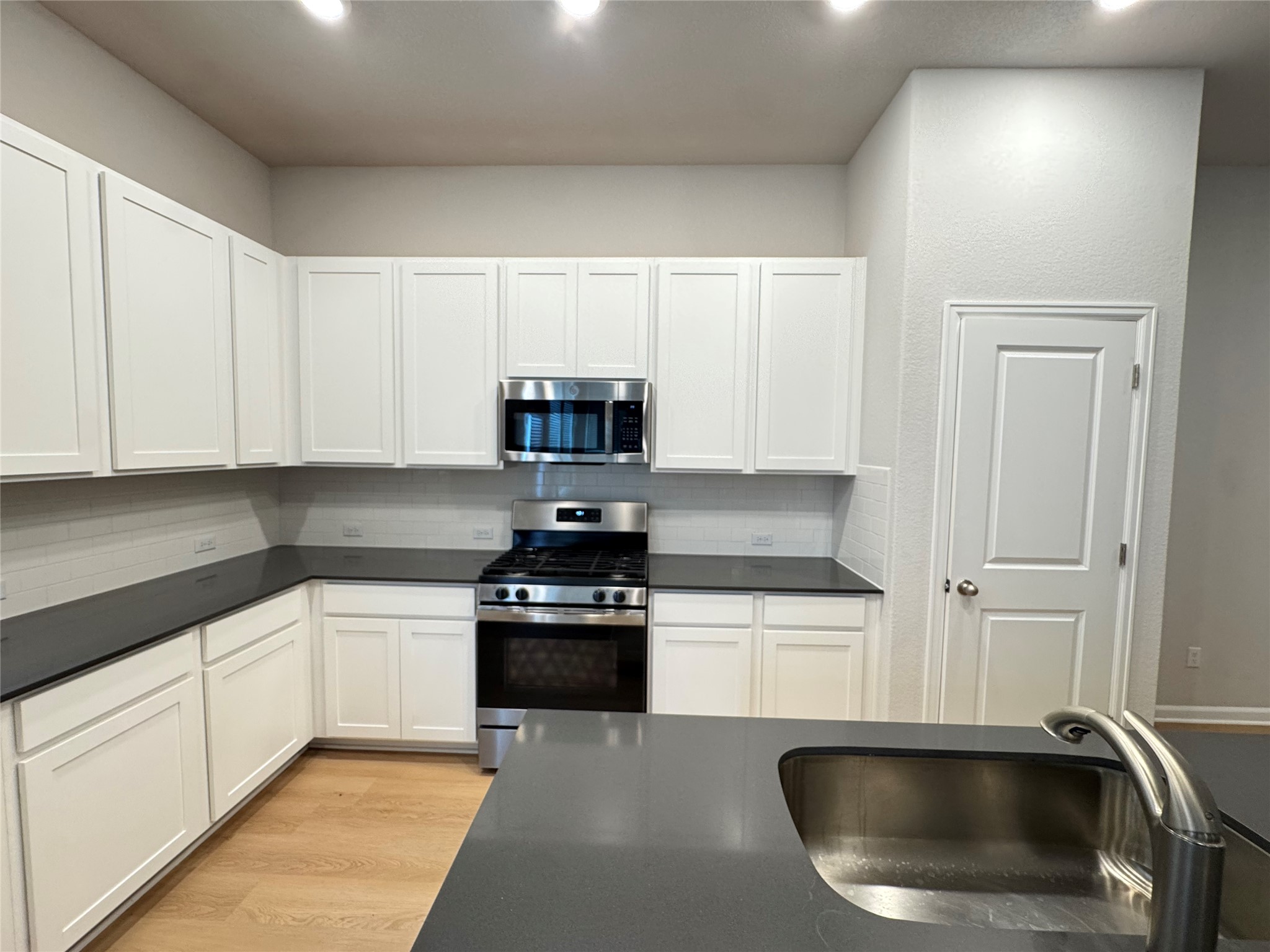 3000 Chisholm Trail Road, Unit 3 Round Rock, TX 78681 - Photo 4 of 28 a kitchen with white cabinets and a sink