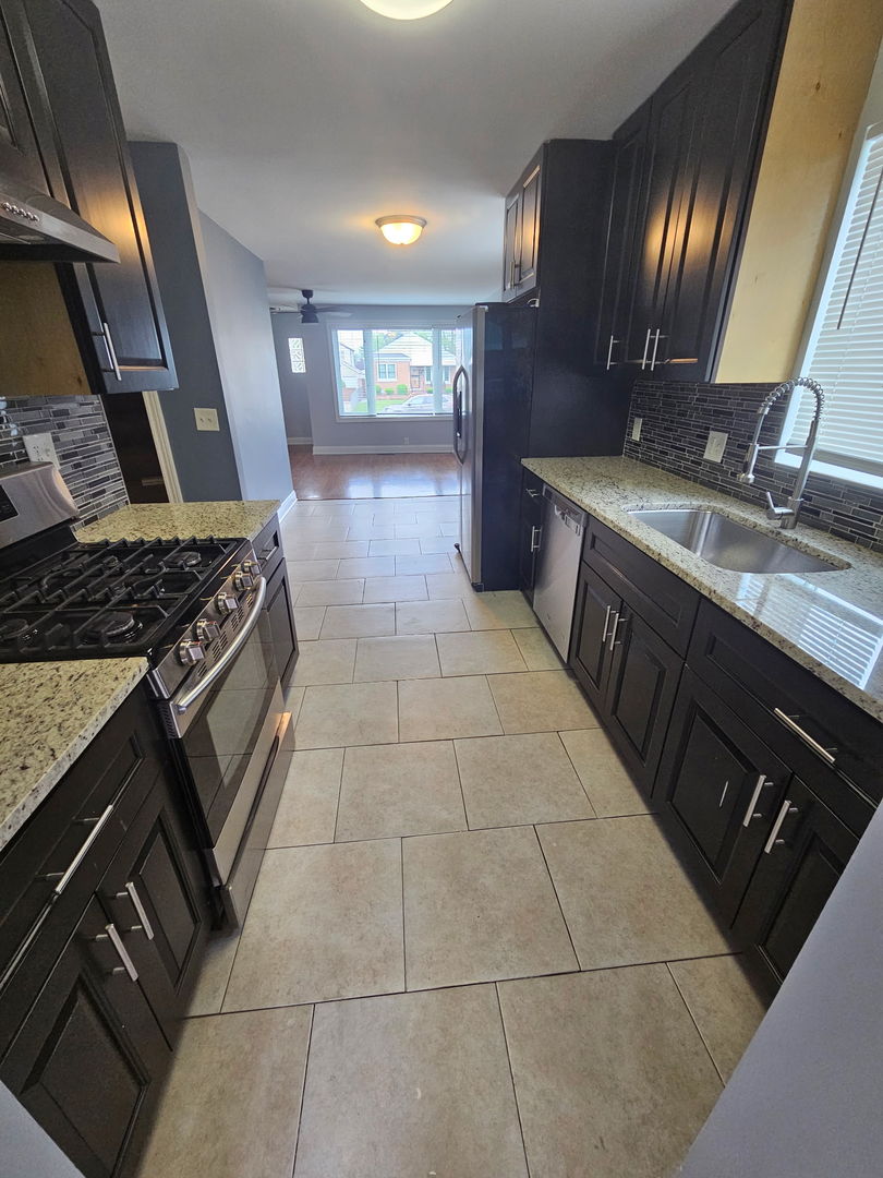 2436 Spruce Street River Grove, IL 60171 - Photo 4 of 19 a kitchen with a sink stove and cabinets