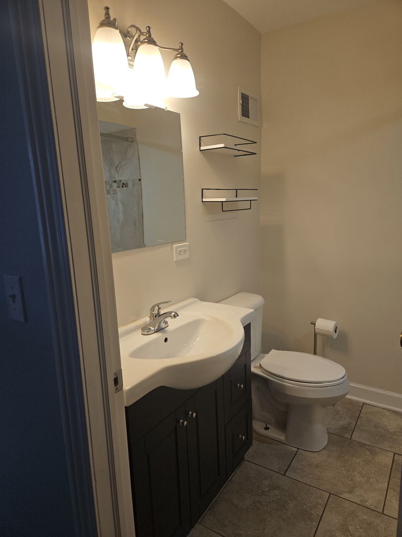 2436 Spruce Street River Grove, IL 60171 - Photo 6 of 19 a bathroom with a toilet sink and mirror