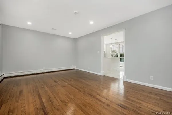 a view of an empty room with wooden floor