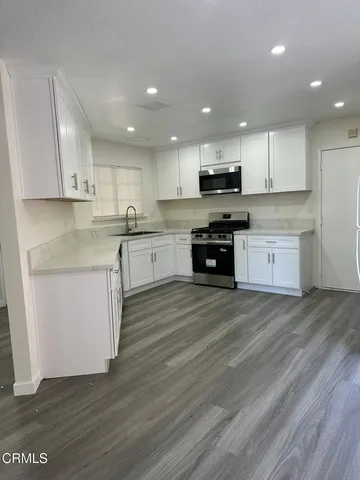 a kitchen with granite countertop a sink and cabinets