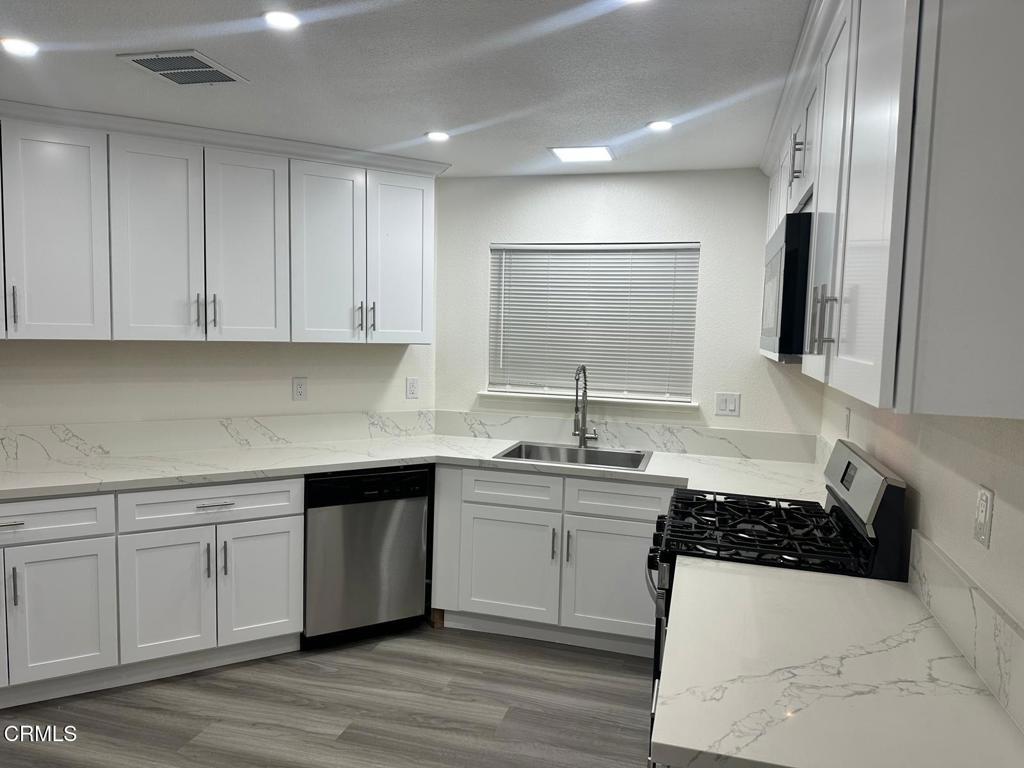 44839 16th Street East Lancaster, CA 93535 - Photo 15 of 53 a kitchen with a sink a stove and cabinets