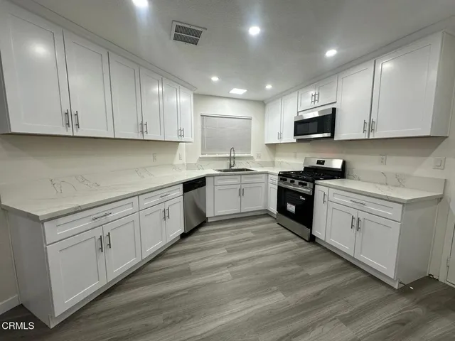 a kitchen with granite countertop white cabinets and white appliances