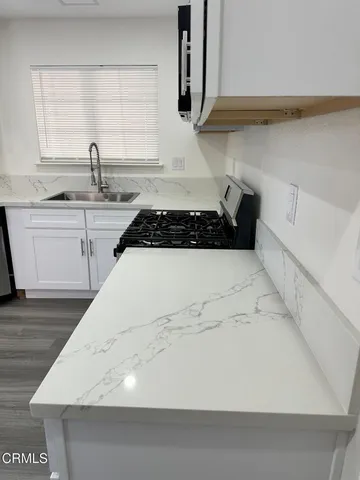 a kitchen with a sink a stove and cabinets