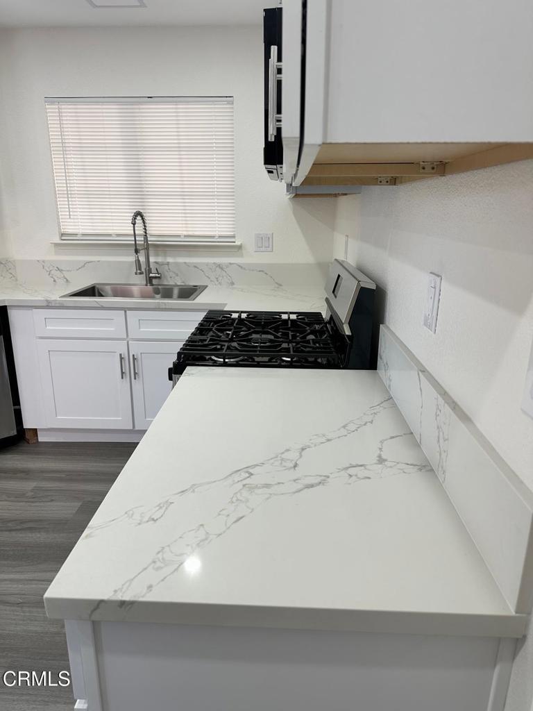 44839 16th Street East Lancaster, CA 93535 - Photo 19 of 53 a kitchen with a sink a stove and cabinets