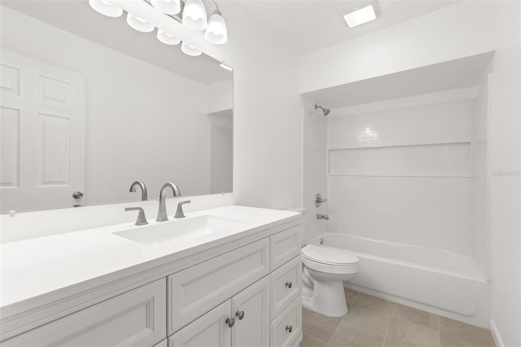 3723 Temple Street Tampa, FL 33619 - Photo 15 of 28 a bathroom with a sink a toilet and a mirror