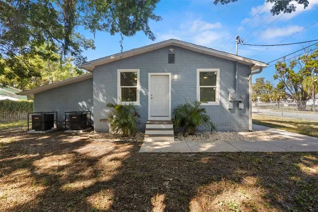 a view of a house with backyard and trees