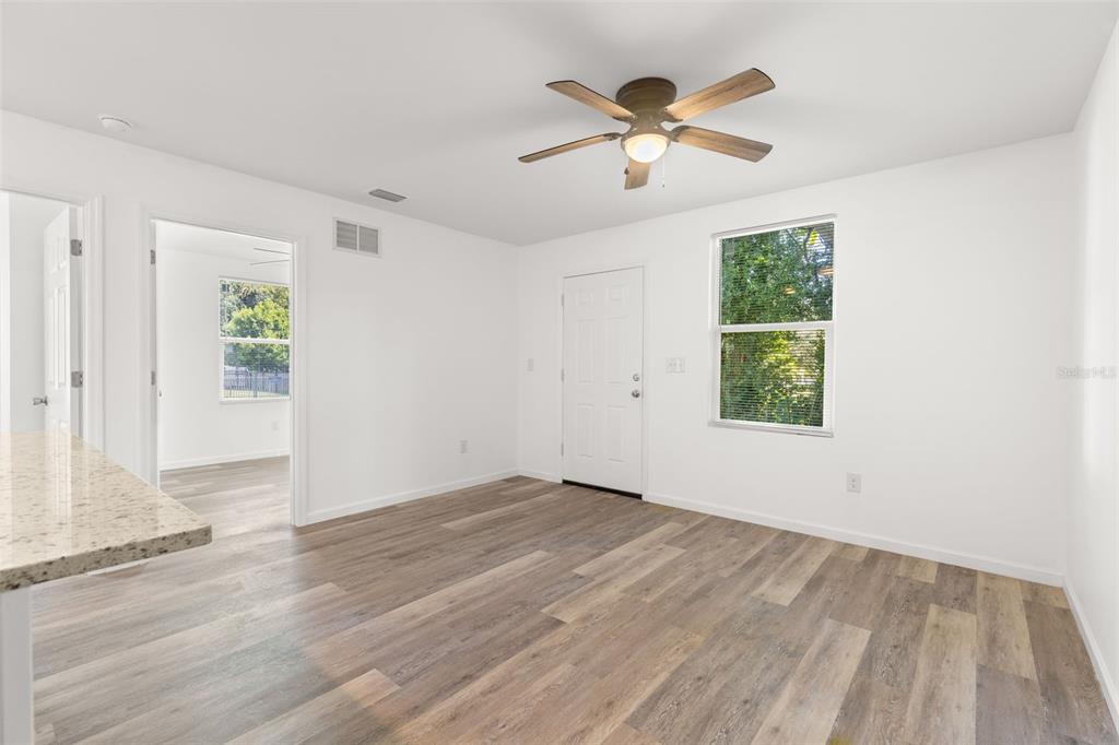 3723 Temple Street Tampa, FL 33619 - Photo 6 of 28 an empty room with wooden floor chandelier fan and windows