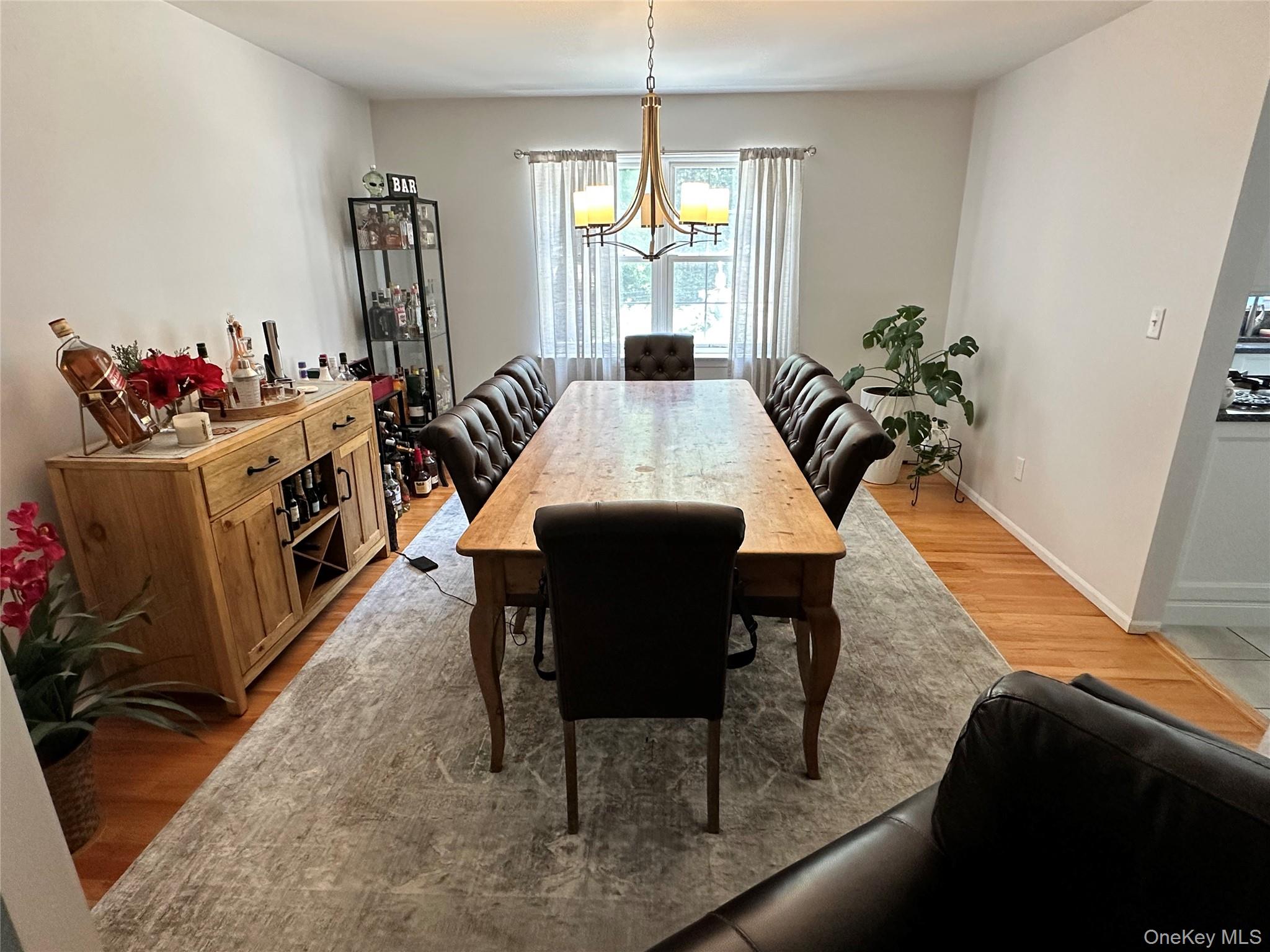 95 Weed Road Pine Bush, NY 12566 - Photo 6 of 31 Spacious dining area featuring hardwood flooring, a large window with privacy blinds, and a central chandelier