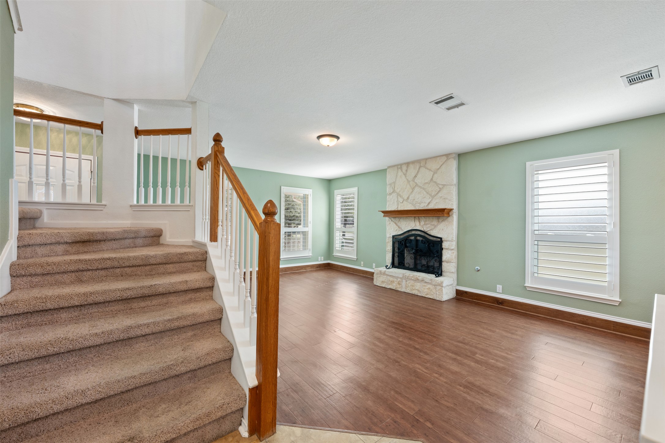104 Sunset Road Georgetown, TX 78633 - Photo 24 of 40 Staircase with wood finished floors and a stone fireplace