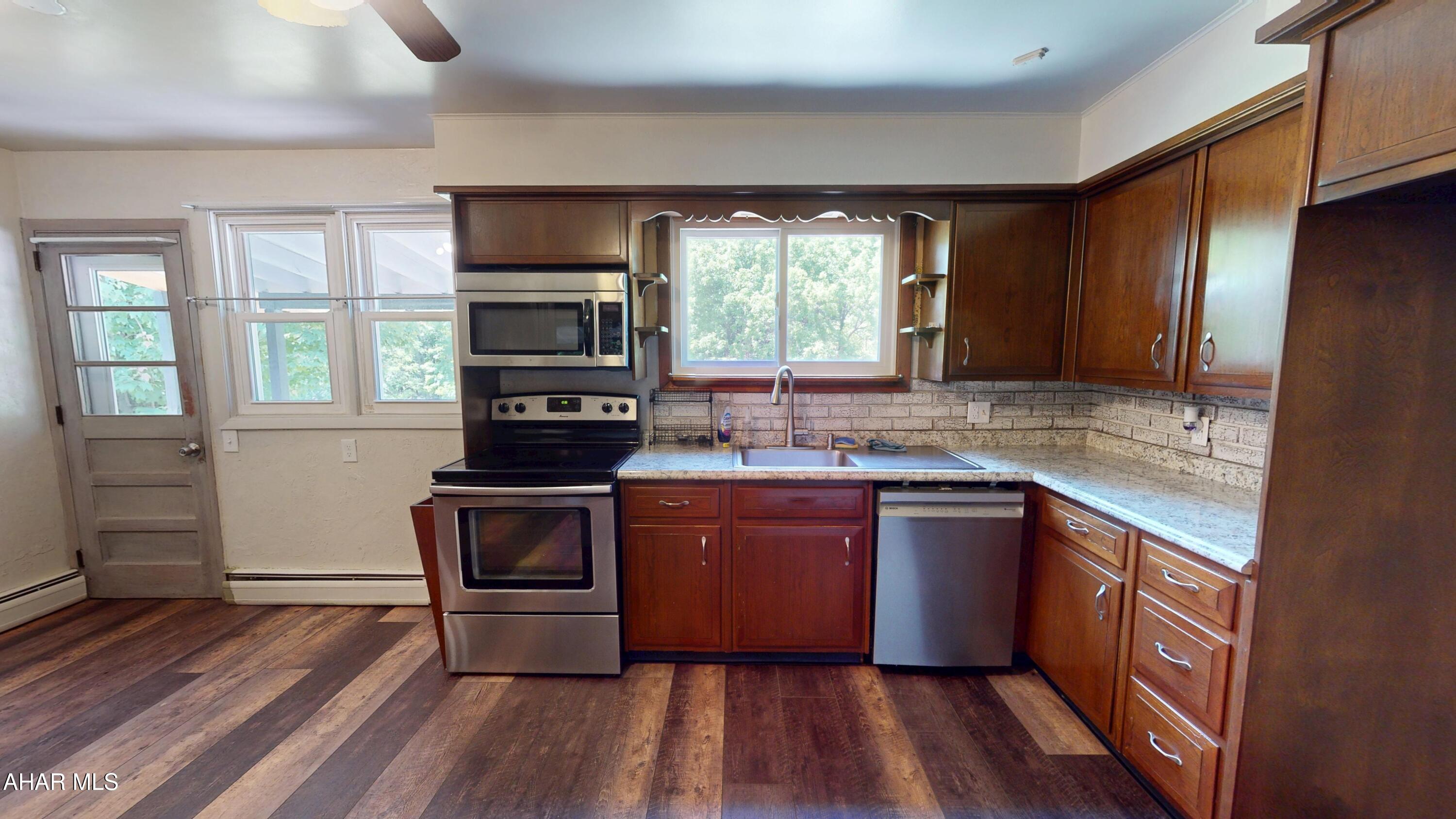 871 Decker Hollow Road Tyrone, PA 16686 - Photo 14 of 35 a kitchen with granite countertop wooden floors and stainless steel appliances