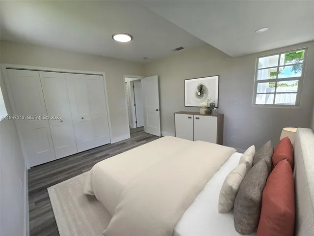 a bedroom with a bed and painting on the wall