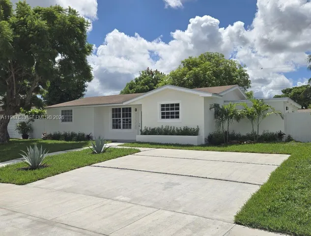 a view of a house with a yard and large tree