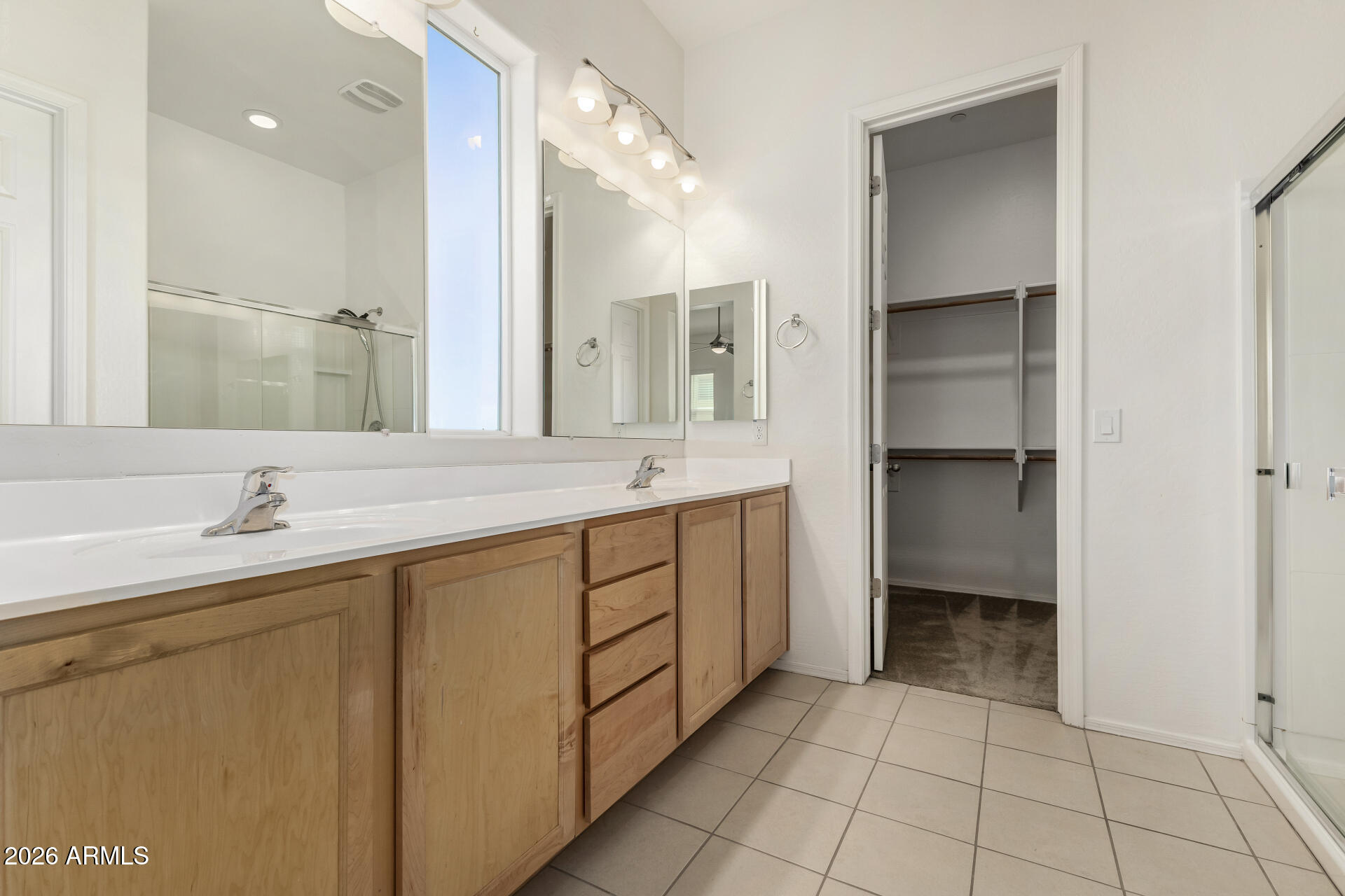 7358 West Phelps Road Peoria, AZ 85382 - Photo 15 of 28 a spacious bathroom with a shower sink and a mirror