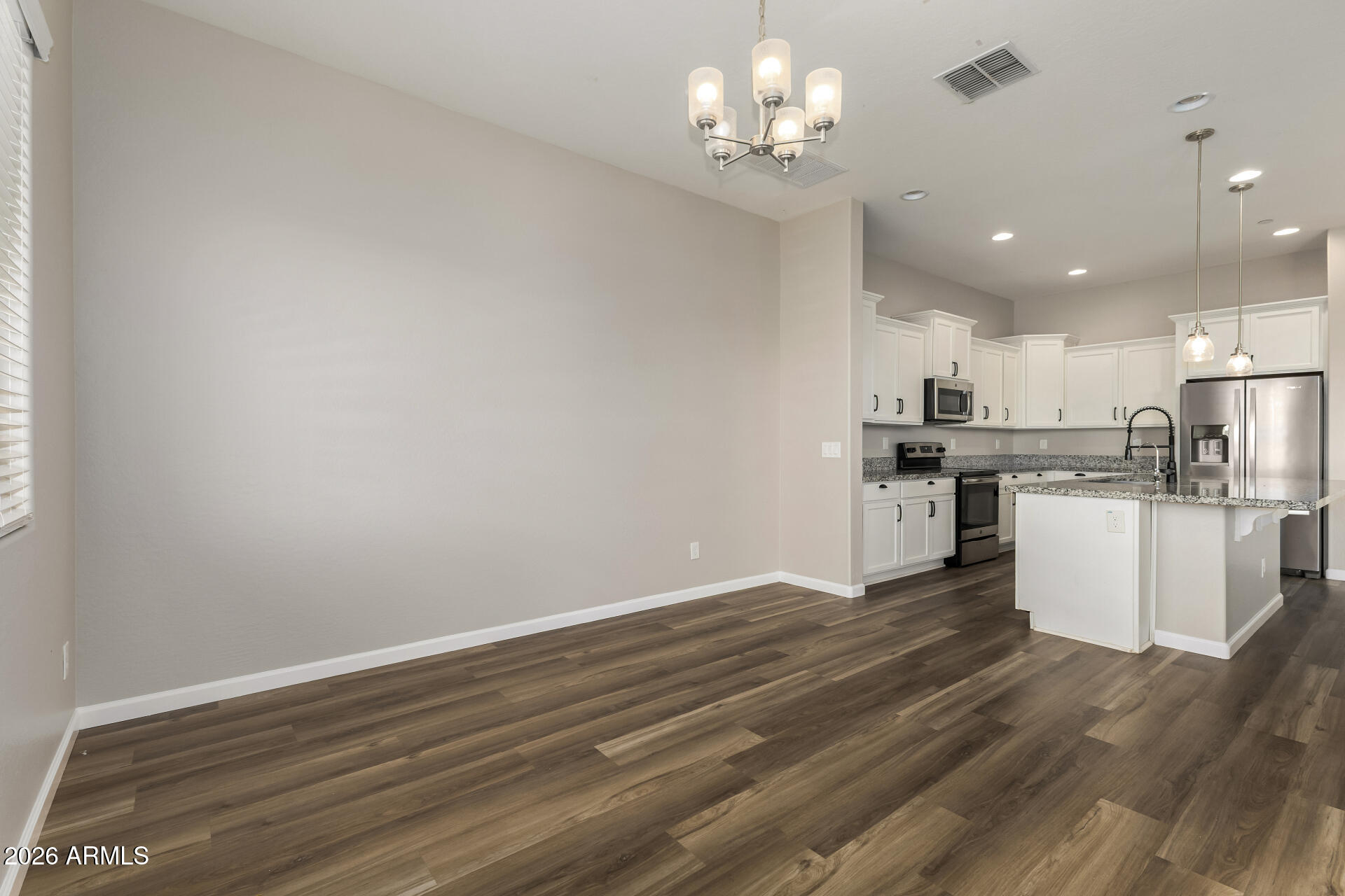 7358 West Phelps Road Peoria, AZ 85382 - Photo 7 of 28 a view of kitchen with granite countertop cabinets and refrigerator