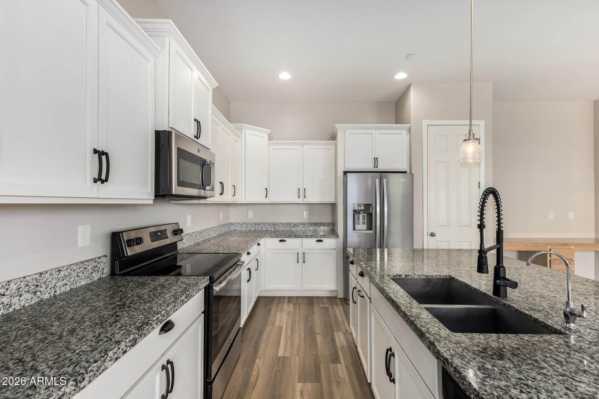 7358 West Phelps Road Peoria, AZ 85382 - Photo 9 of 28 a kitchen with stainless steel appliances granite countertop a sink stove and refrigerator