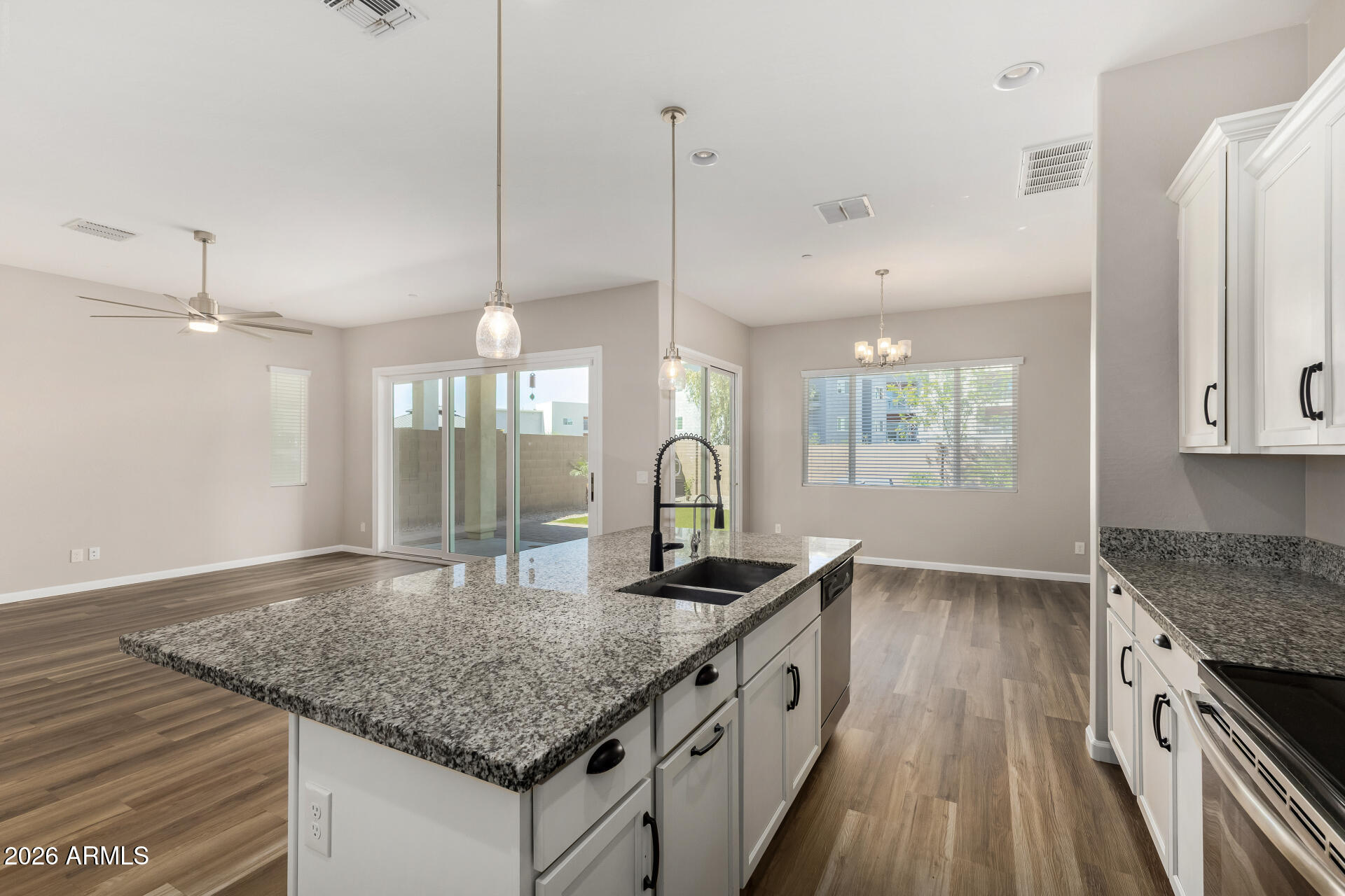 7358 West Phelps Road Peoria, AZ 85382 - Photo 10 of 28 a kitchen with granite countertop kitchen island a stove and a sink