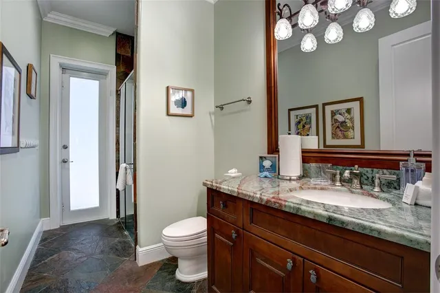 a bathroom with a granite countertop toilet sink and mirror