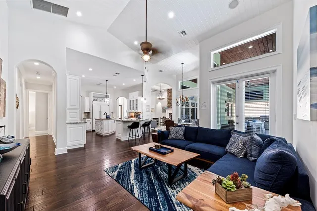 a living room with lots of furniture and a large mirror with wooden floor