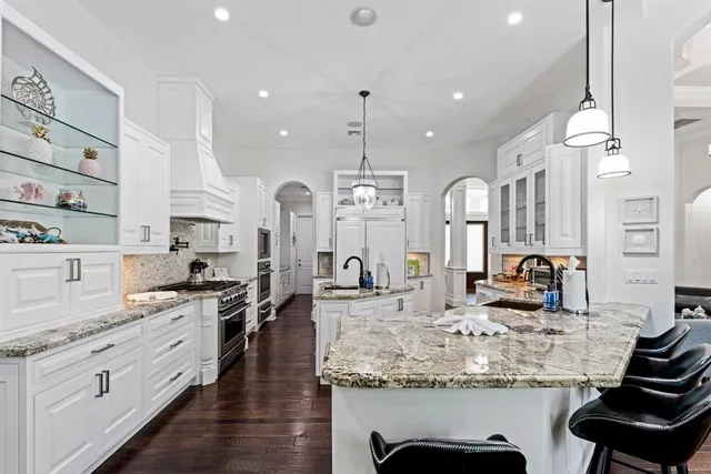 a kitchen with stainless steel appliances granite countertop a sink stove and cabinets