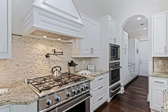 a stove top oven sitting inside of a kitchen
