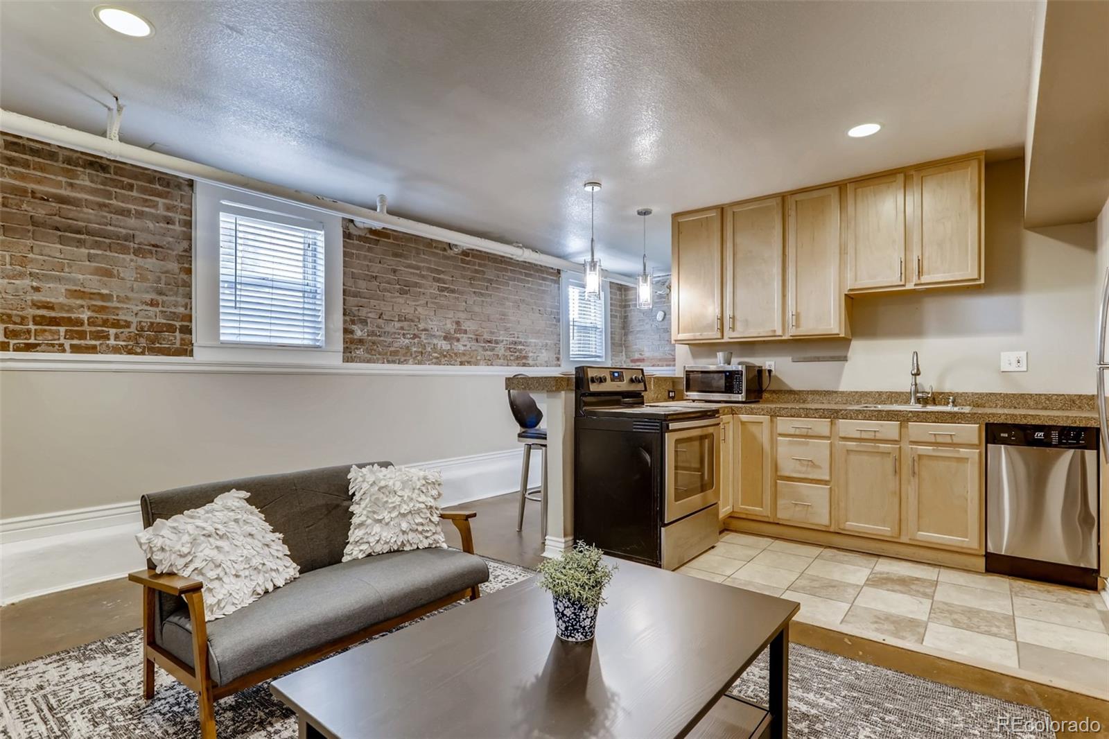 a kitchen with stainless steel appliances kitchen island granite countertop a refrigerator a stove a sink dishwasher with a dining table and chairs