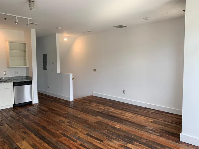 a view of kitchen with granite countertop cabinets and wooden floor