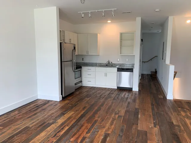 a kitchen with a refrigerator and a stove top oven