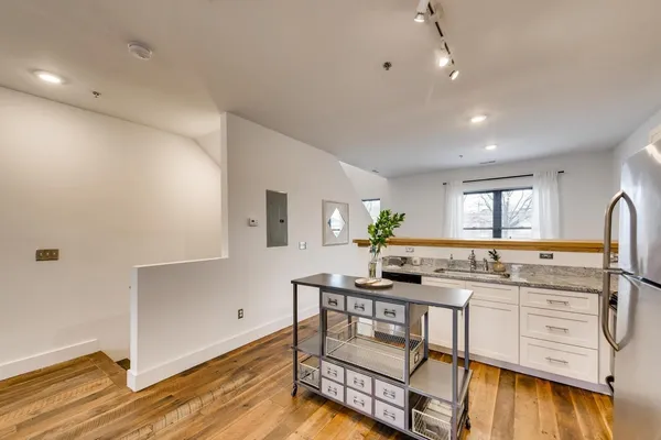 a kitchen with stainless steel appliances kitchen island granite countertop a sink and cabinets