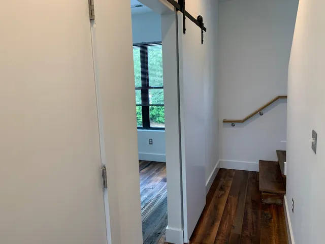 a view of hallway with stairs and a wooden floor