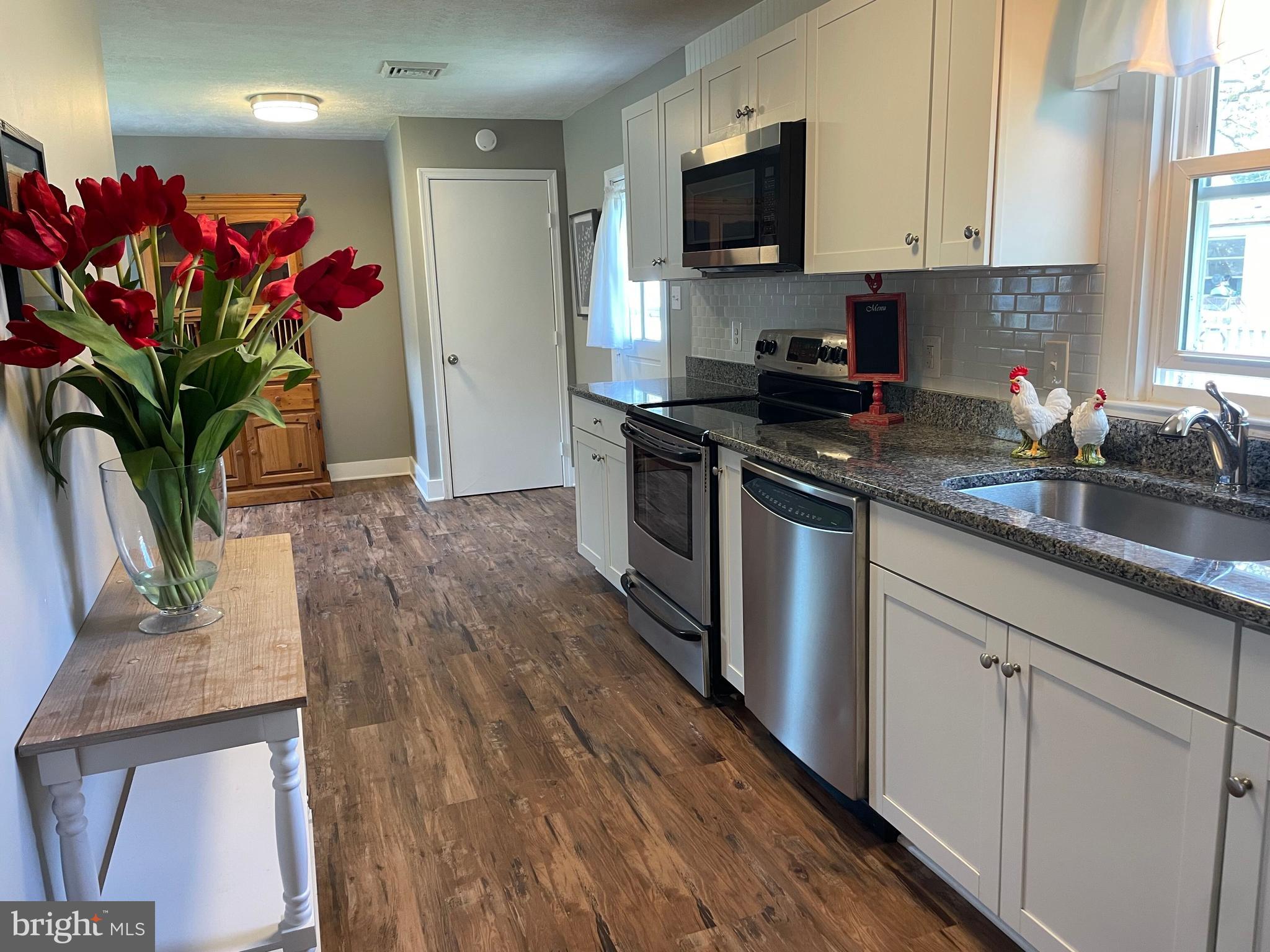 5 Oak Street Cambridge, MD 21613 - Photo 13 of 31 a kitchen with stainless steel appliances granite countertop a sink a stove and a wooden floors