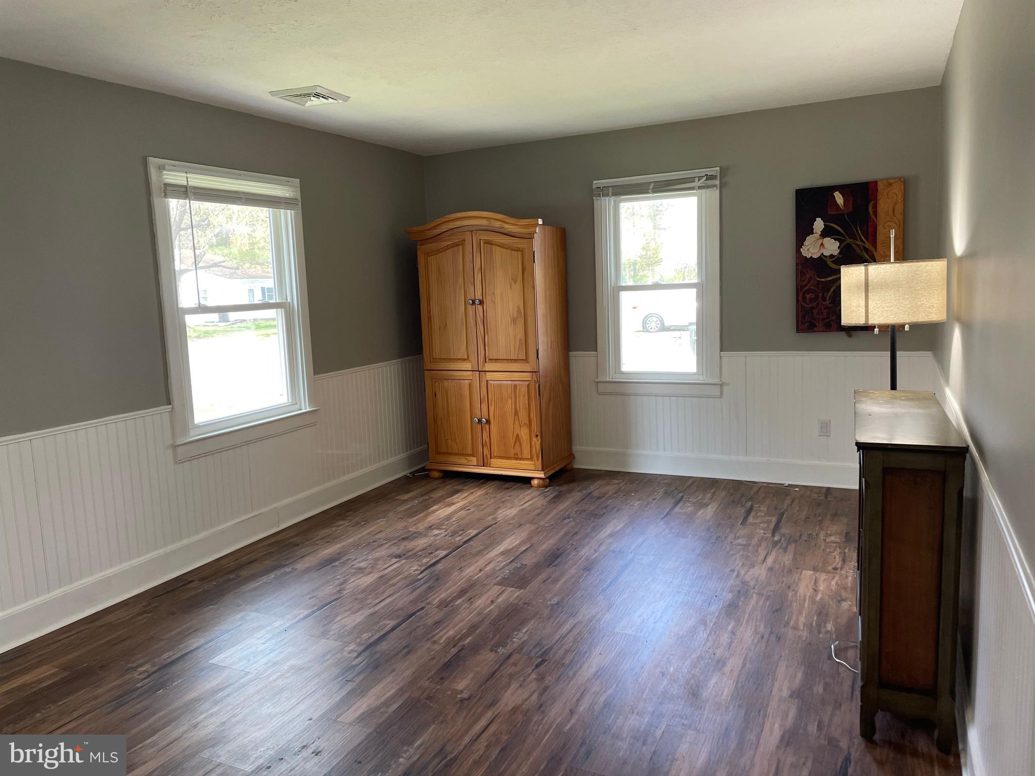 5 Oak Street Cambridge, MD 21613 - Photo 6 of 31 an empty room with wooden floor cabinet and windows