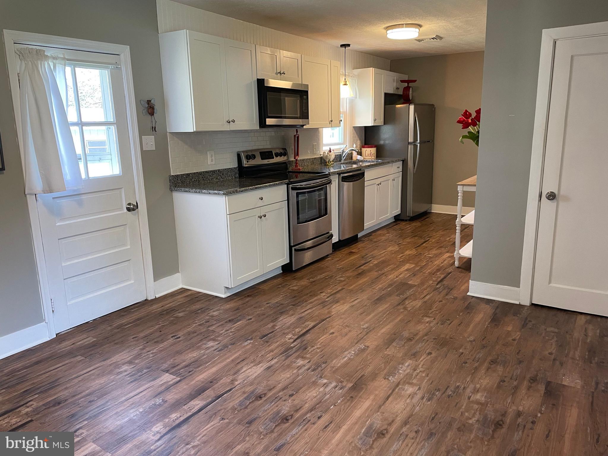 5 Oak Street Cambridge, MD 21613 - Photo 8 of 31 a kitchen with granite countertop a refrigerator stove top oven and sink