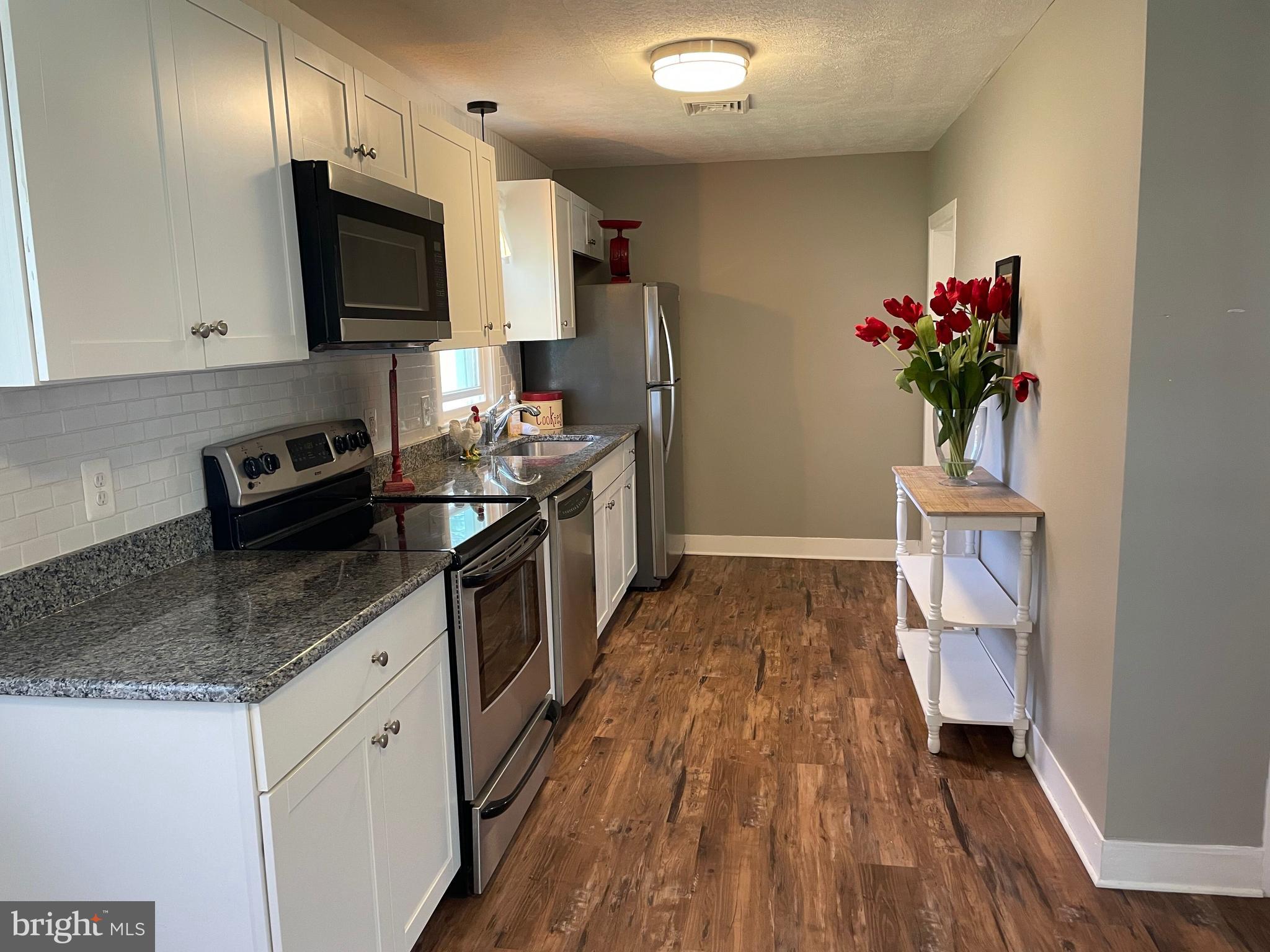 5 Oak Street Cambridge, MD 21613 - Photo 10 of 31 a kitchen with a sink stove and refrigerator