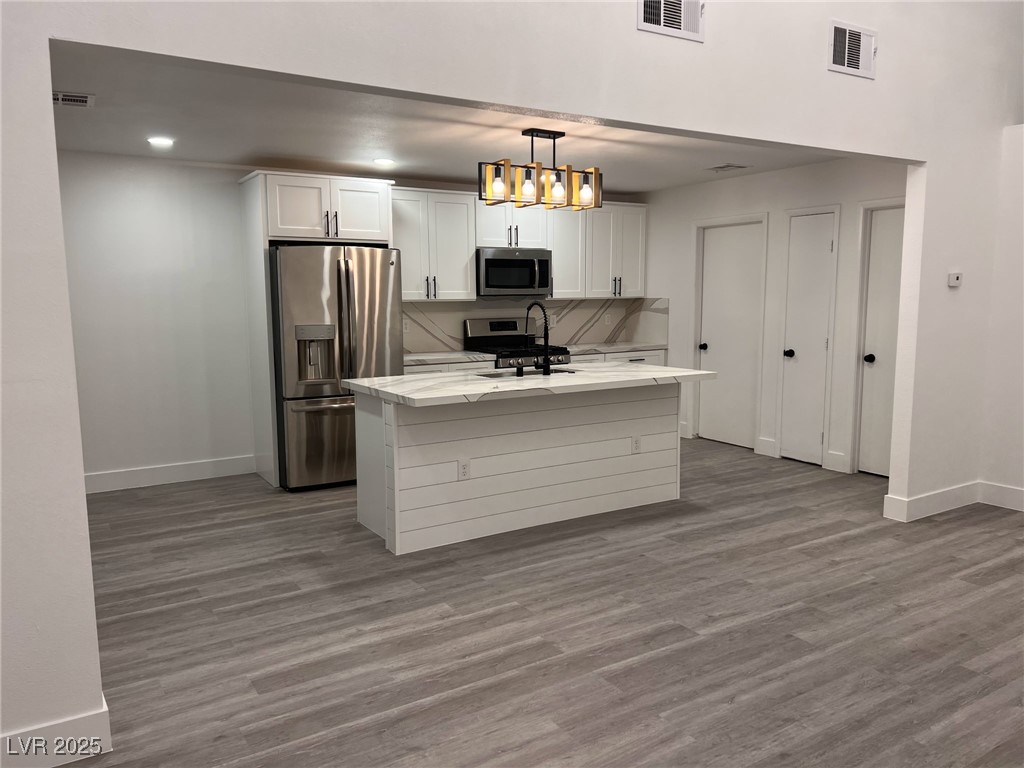 3686 Lincoln Road Las Vegas, NV 89115 - Photo 10 of 26 Kitchen featuring white cabinets, visible vents, b