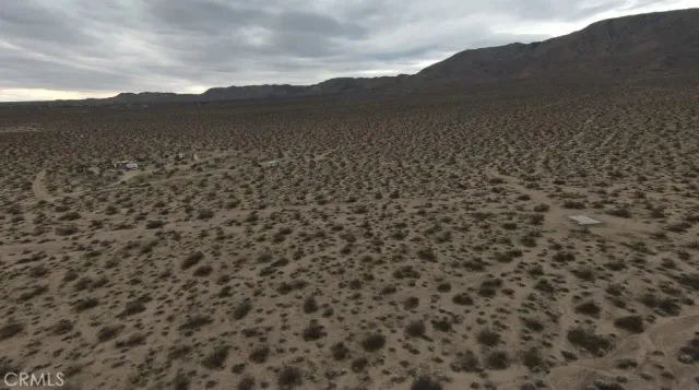 a view of a field with mountains in the background