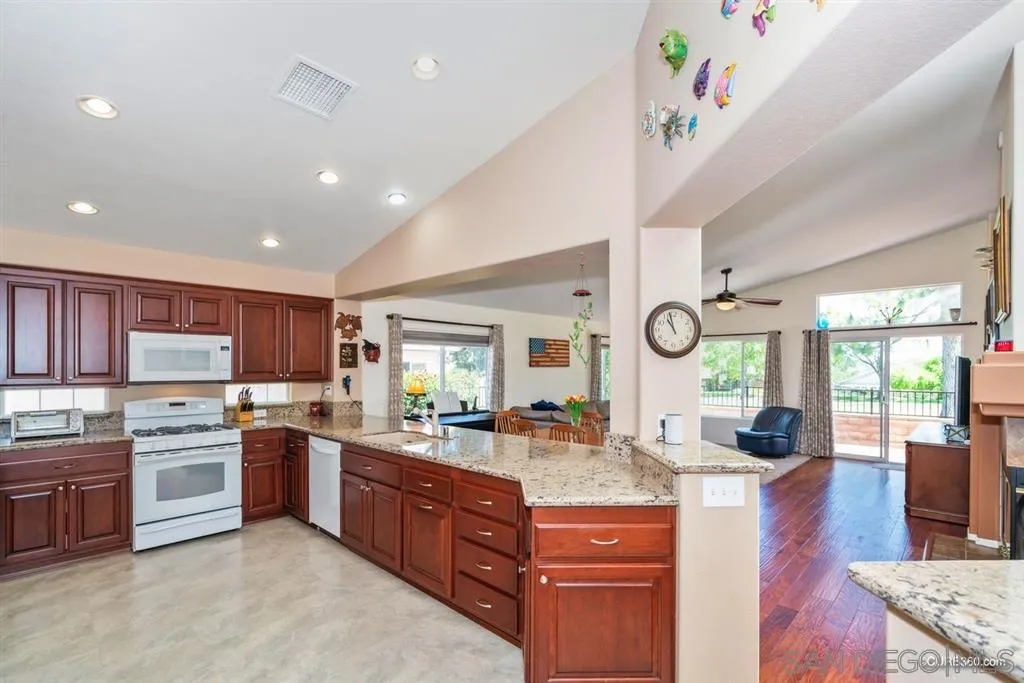 2332 Columbine Road Alpine, CA 91901 - Photo 5 of 25 a kitchen with stainless steel appliances granite countertop a stove top oven a sink dishwasher and a dining table with wooden floor