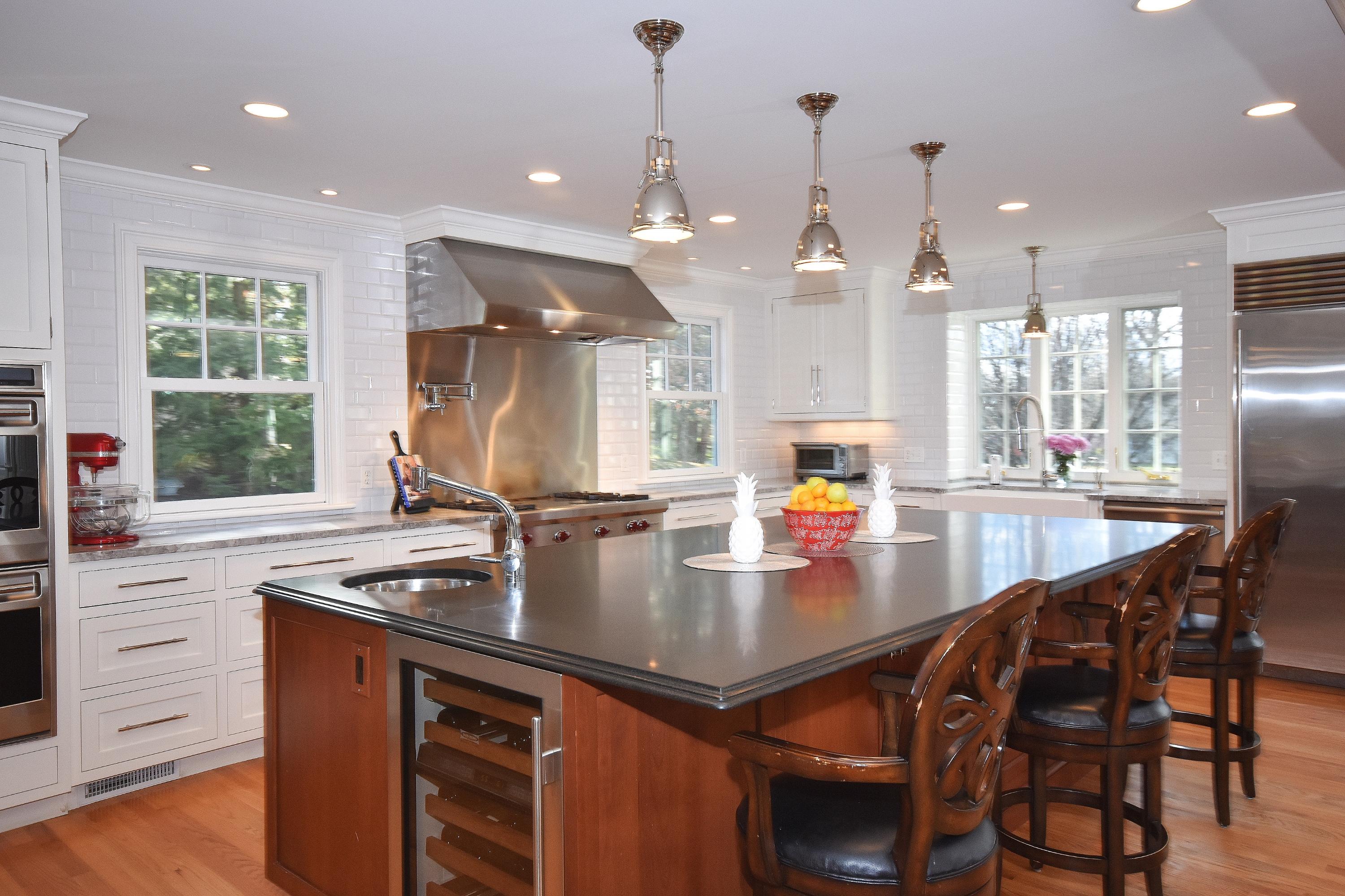 10 Barringer Road Darien, CT 06820 - Photo 10 of 27 a kitchen with stainless steel appliances granite countertop a stove a sink a oven a dining table and chairs with wooden floor