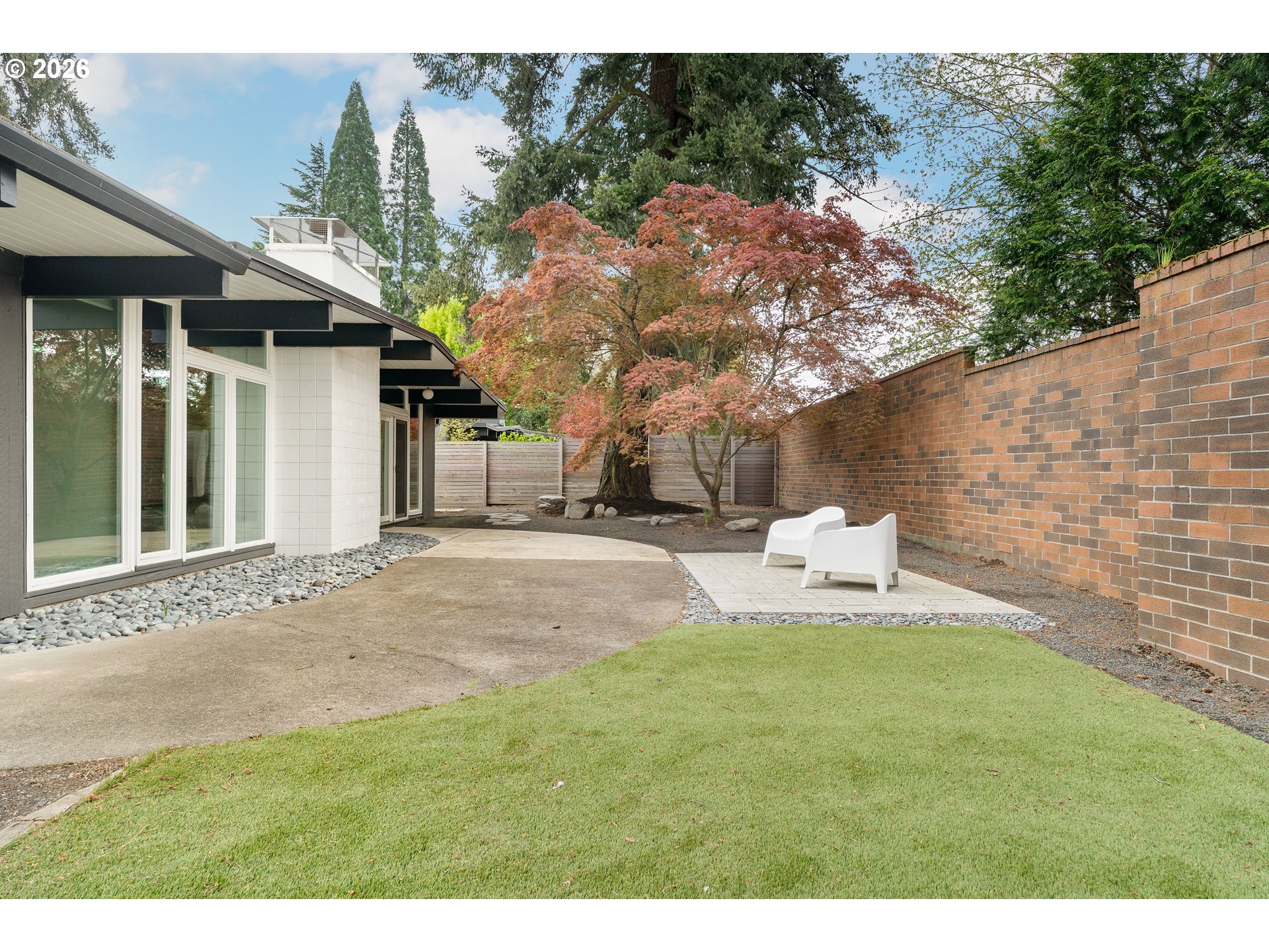 7125 Southwest 105th Avenue Beaverton, OR 97008 - Photo 36 of 39 a view of a white house with a yard and sitting area