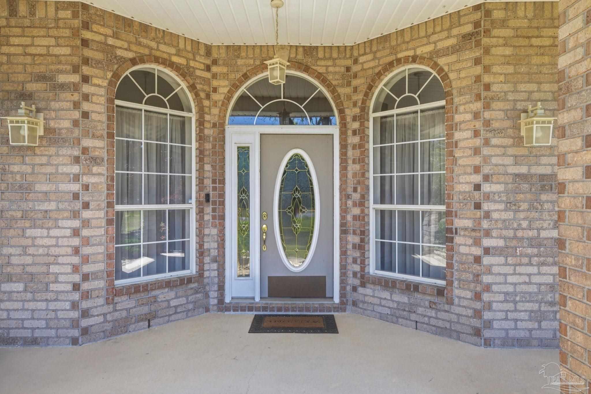 4552 Peaden Road Pace, FL 32571 - Photo 5 of 38 a front view of a house with garden