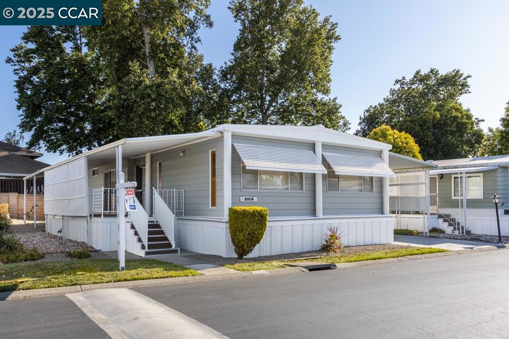 a view of a house with backyard and sitting area