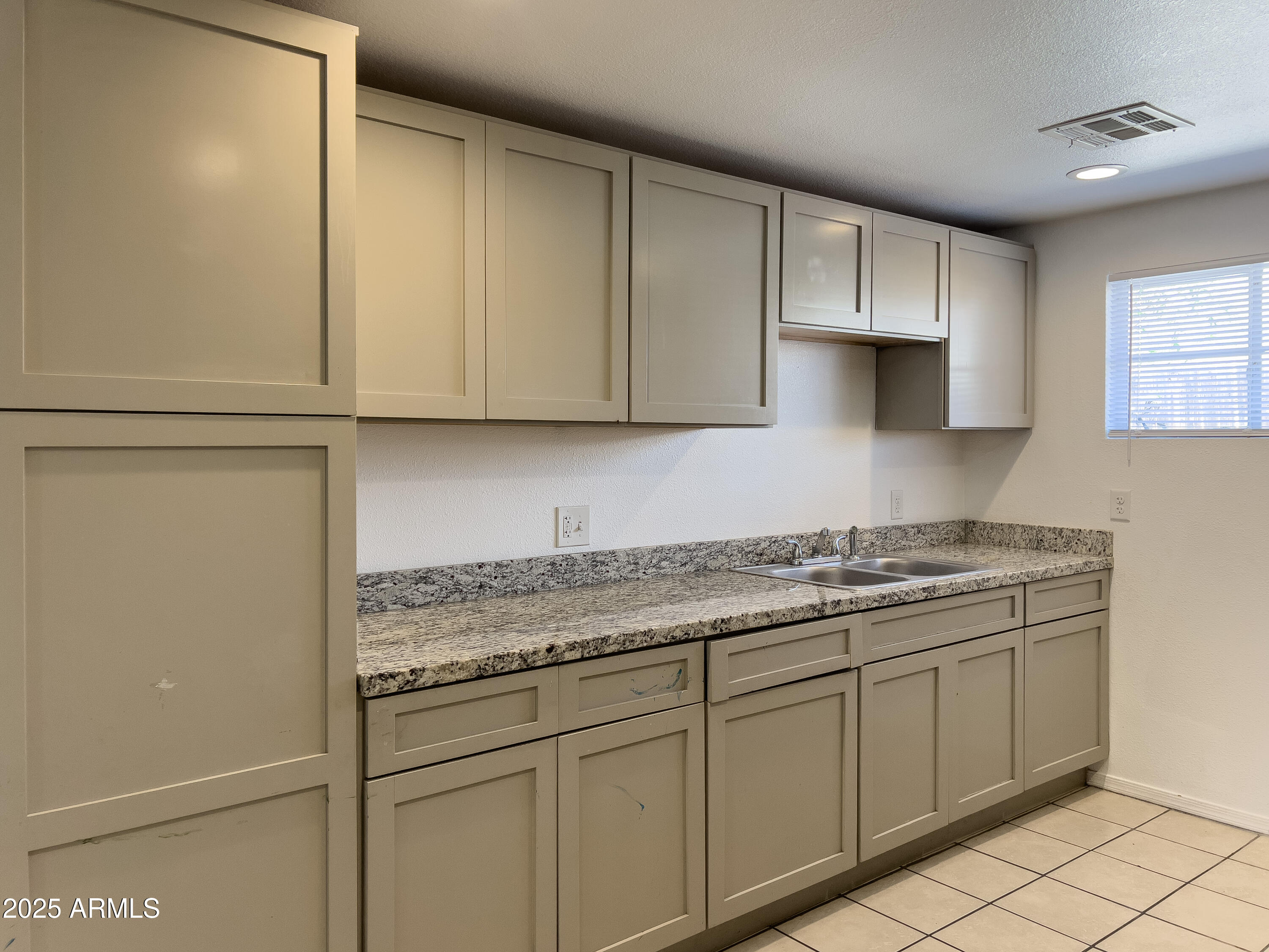 1520 West Sahuaro Drive, Unit B Phoenix, AZ 85029 - Photo 11 of 25 a kitchen with granite countertop white cabinets and stainless steel appliances