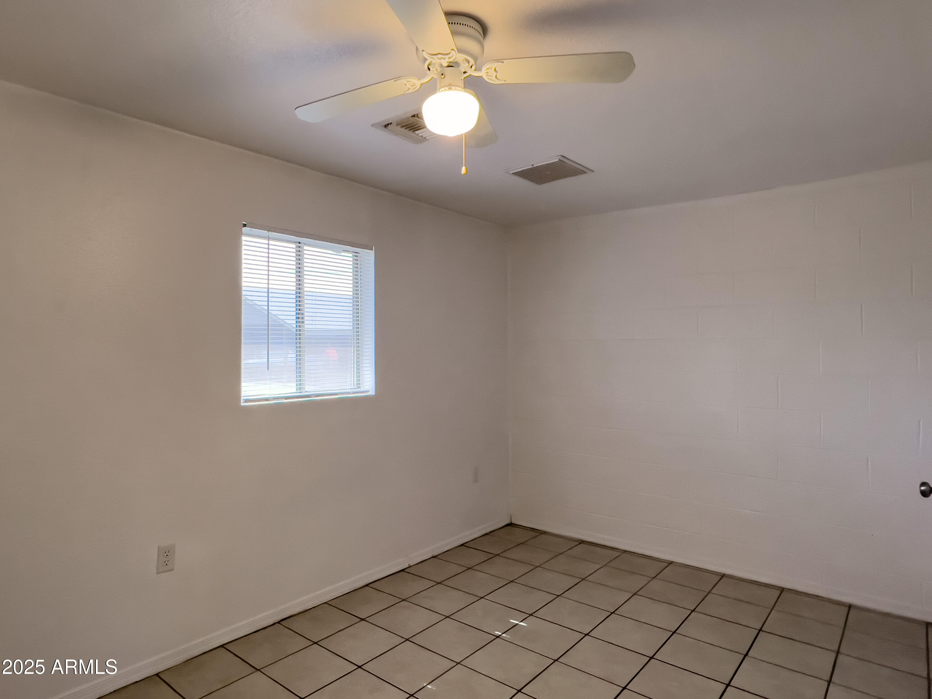 1520 West Sahuaro Drive, Unit B Phoenix, AZ 85029 - Photo 14 of 25 an empty room with chandelier fan