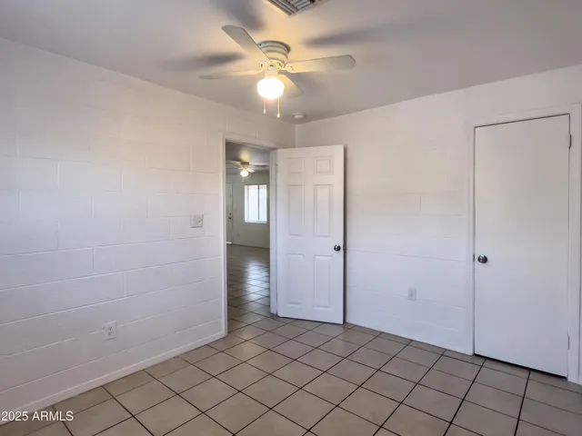 an empty room with a window and a fan