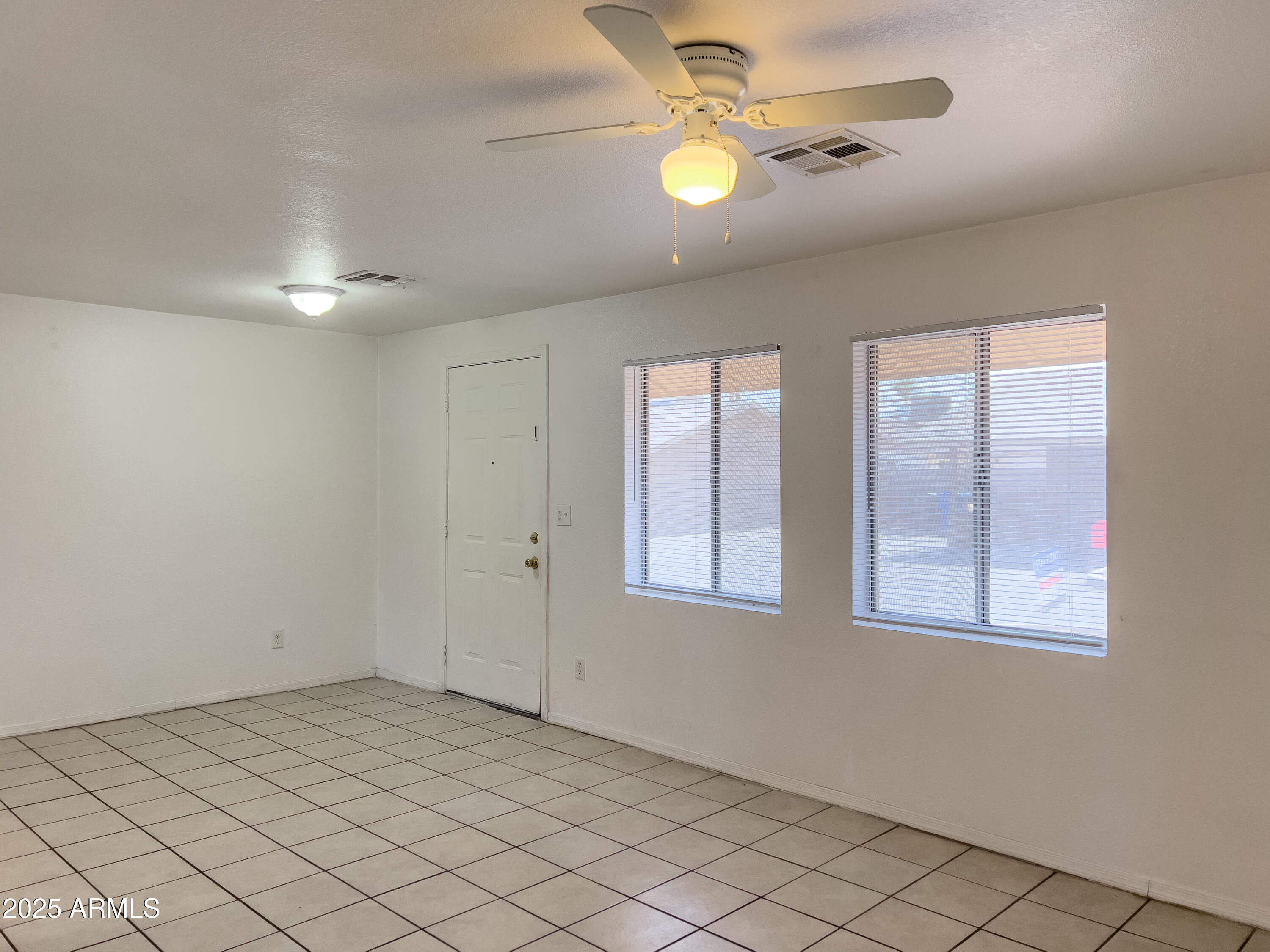 1520 West Sahuaro Drive, Unit B Phoenix, AZ 85029 - Photo 8 of 25 an empty room with windows and fan